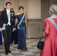 Empunya acara muncul dalam balutan tuksedo berdasi putih yang dihiasi selempang biru muda. Kedua orangtuanya juga memakai selempang sama. Sementara itu, Ratu Margrethe II yang saat ini sudah berusia 83 tahun berbalut gaun merah muda yang dihiasi sejumlah atribut kerajaan. Tidak ketinggalan, mahkota di kepala. (Foto: Mads Claus Rasmussen/Ritzau Scanpix via AP)