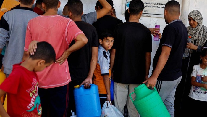 Potret Anak-anak Palestina Antre Air Bersih Palestinians gather to collect water, amid shortages of drinking water, as the Israeli-Palestinian conflict continues, in Khan Younis in the southern Gaza Strip October 15, 2023. REUTERS/Mohammed Salem TPX IMAGES OF THE DAY