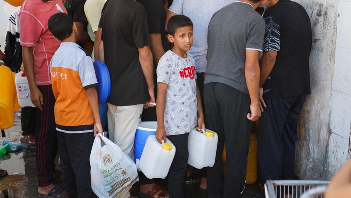 Potret Anak-anak Palestina Antre Air Bersih Palestinians gather to collect water, amid shortages of drinking water, as the Israeli-Palestinian conflict continues, in Khan Younis in the southern Gaza Strip October 15, 2023. REUTERS/Mohammed Salem TPX IMAGES OF THE DAY
