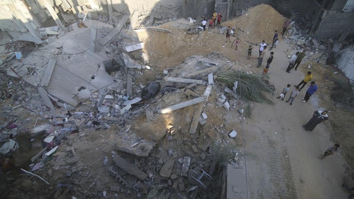 Palestinians search for survivors in the building of the Zanon family, destroyed in Israeli airstrikes in Rafah, Gaza Strip, Saturday, Oct. 14, 2023. (AP Photo/Hatem Ali)