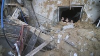 Anak-anak Palestina memandangi bangunan keluarga Zanon yang hancur akibat serangan udara Israel di Rafah, Jalur Gaza, Sabtu (14/10/2023).