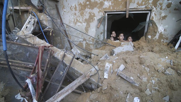 Palestinians search for survivors in the building of the Zanon family, destroyed in Israeli airstrikes in Rafah, Gaza Strip, Saturday, Oct. 14, 2023. (AP Photo/Hatem Ali)