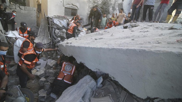 Palestinians search for survivors in the building of the Zanon family, destroyed in Israeli airstrikes in Rafah, Gaza Strip, Saturday, Oct. 14, 2023. (AP Photo/Hatem Ali)