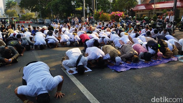 Sekelompok massa kembali ke Patung Kuda untuk melakukan sujud syukur setelah mendengar MK mengabulkan soal gugatan batas minimal capres-cawapres. (Kurniawan F/detikcom)