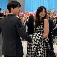 Dalam kesempatan itu, Song Joong Ki tampak gagah memakai setelan jas hitam. Sedangkan istrinya, Katy Louise Saunders memesona dalam balutan dress bermotif kotak-kotak yang senada dengan coat-nya.Foto: dok. Twitter @sjkwings1985, dok. Twitter @sang_nihal