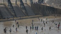 Warga mencari ikan memanfaatkan ditutupnya saluran irigasi Bendungan Colo di Nguter, Sukoharjo, Jawa Tengah, Senin (16/10/2022).   