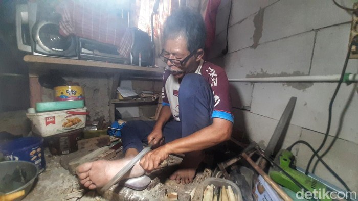 Idin saat mengolah tulang kaki sapi jadi kerajinan yang indah.