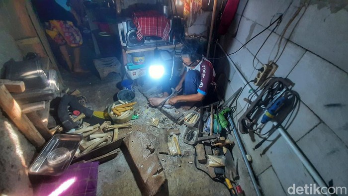 Idin saat mengolah tulang kaki sapi jadi kerajinan yang indah.