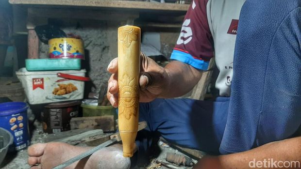Idin saat mengolah tulang kaki sapi jadi kerajinan yang indah.