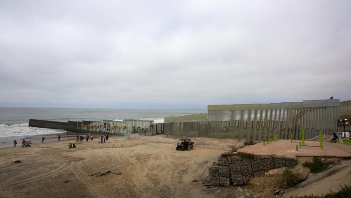 People observe a construction crew working in the replacement of the corroded primary border wall between Mexico and U.S., as seen from Playas de Tijuana, Mexico October 16, 2023. REUTERS/Jorge Duenes