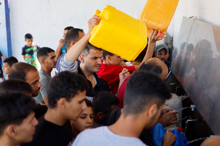 Palestinians gather to collect water, amid shortages of drinking water, as the Israeli-Palestinian conflict continues, in Khan Younis in the southern Gaza Strip October 15, 2023. REUTERS/Mohammed Salem