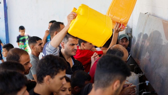 Krisis Air Melanda Warga Gaza Akibat Israel Blokade Akses Palestinians gather to collect water, amid shortages of drinking water, as the Israeli-Palestinian conflict continues, in Khan Younis in the southern Gaza Strip October 15, 2023. REUTERS/Mohammed Salem