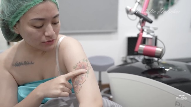 “Ini aku udah berkali-kali buat hapus. Cuma kalau yang berwarna ini lebih susah hilang,” ungkap Nathalie sambil menunjuk tato bergambar bunga di lengan tangannya. Foto: dok. YouTube Nathalie Holscher