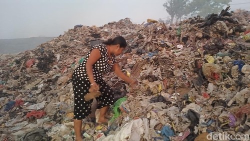 Norlina Neolaka saat mengumpulkan sisa-sisa sampah plastik dan besi bekas di TPA Alak, Kota Kupang, NTT, Selasa (17/10/2023). (Foto: Yufengki Bria/detikBali)