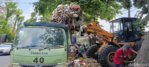 Petugas mengangkut tumpukan sampah di Tempat Pembuangan Sementara (TPS) Yang Batu, Denpasar, Bali, Selasa (17/10/2023). (Ni Made Lastri Karsiani Putri/detikBali)
