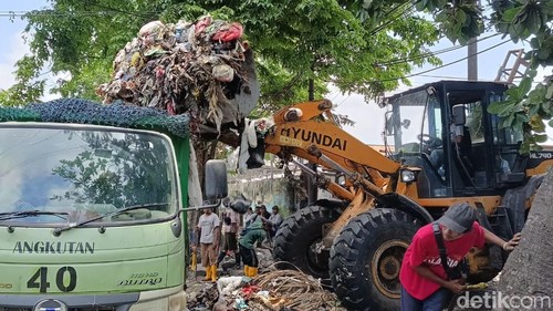 Petugas mengangkut tumpukan sampah di Tempat Pembuangan Sementara (TPS) Yang Batu, Denpasar, Bali, Selasa (17/10/2023). (Ni Made Lastri Karsiani Putri/detikBali)