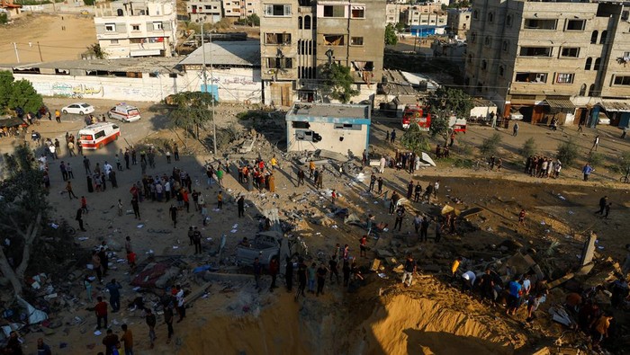 Palestinians gather at a site of Israeli strikes in Khan Younis in the southern Gaza Strip October 16, 2023. REUTERS/Ibraheem Abu Mustafa