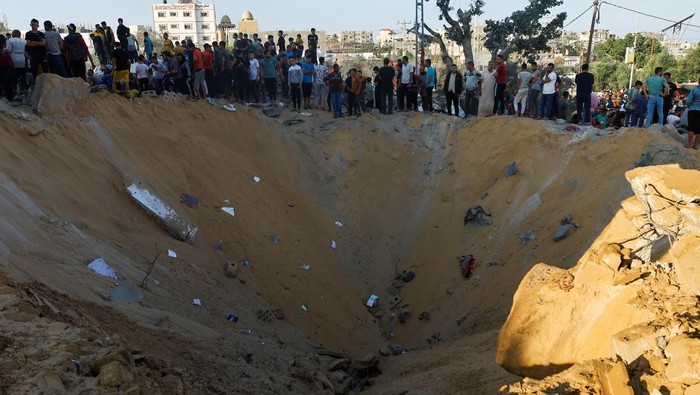 Palestinians gather at a site of Israeli strikes in Khan Younis in the southern Gaza Strip October 16, 2023. REUTERS/Ibraheem Abu Mustafa