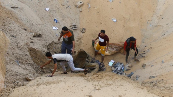 Palestinians gather at a site of Israeli strikes in Khan Younis in the southern Gaza Strip October 16, 2023. REUTERS/Ibraheem Abu Mustafa