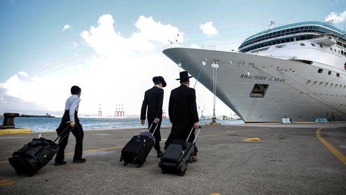 People wheel their luggage as U.S. nationals and their immediate family members leave Israel on a ship headed for Cyprus, amid the ongoing conflict between Israel and the Palestinian Islamist group Hamas, in Haifa, Israel, October 16, 2023. REUTERS/Shir Torem