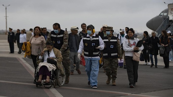 Potret Warga Peru Dievakuasi dari Israel dengan Pesawat Kepresidenan Peruvian President Diana Boluarte, left, leads Peruvians repatriated from Israel, down the stairway after landing in the presidential plane at the air force base in Callao, Peru, Sunday, Oct. 15, 2023. (AP Photo/Guadalupe Pardo)