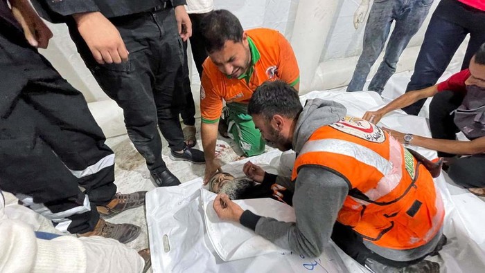 Members of a Palestinian civil emergency team react after several colleagues were killed in Israeli strikes, at Shifa Hospital in Gaza City October 16, 2023. REUTERS/Mohammed al-Masri