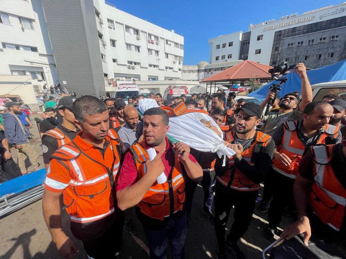 Members of a Palestinian civil emergency team react after several colleagues were killed in Israeli strikes, at Shifa Hospital in Gaza City October 16, 2023. REUTERS/Mohammed al-Masri