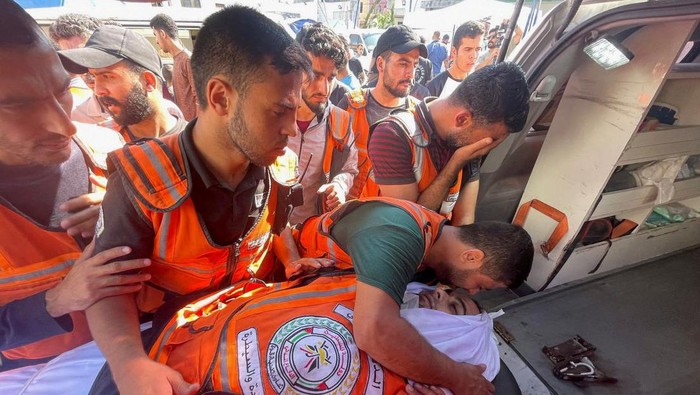 Relawan Kemanusiaan Turut Jadi Korban Tewas Serangan Israel Members of a Palestinian civil emergency team react after several colleagues were killed in Israeli strikes, at Shifa Hospital in Gaza City October 16, 2023. REUTERS/Mohammed al-Masri