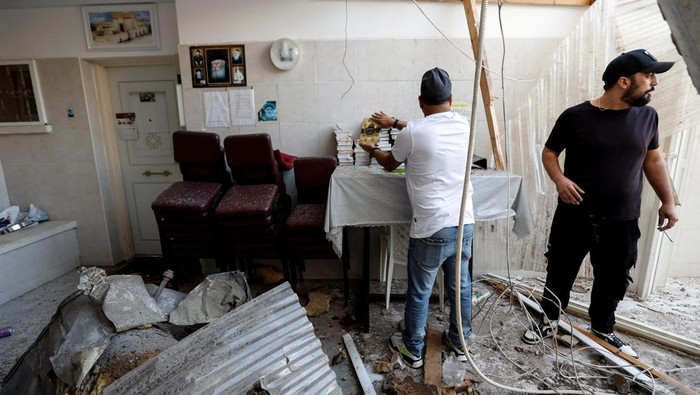 Rumah di Ashkelon Ini Hancur Terkena Hantaman Roket Hamas A man organises Jewish prayer books after a synagogue was hit by a rocket launched from the Gaza Strip into Israel, in Ashkelon, southern Israel October 15, 2023. REUTERS/Amir Cohen