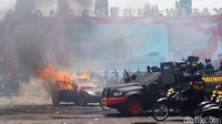 Sejumlha petugas kepolisian mengahalau massa yang melakukan pembakaran mobil pada saat simulasi Sispamkota 2023.