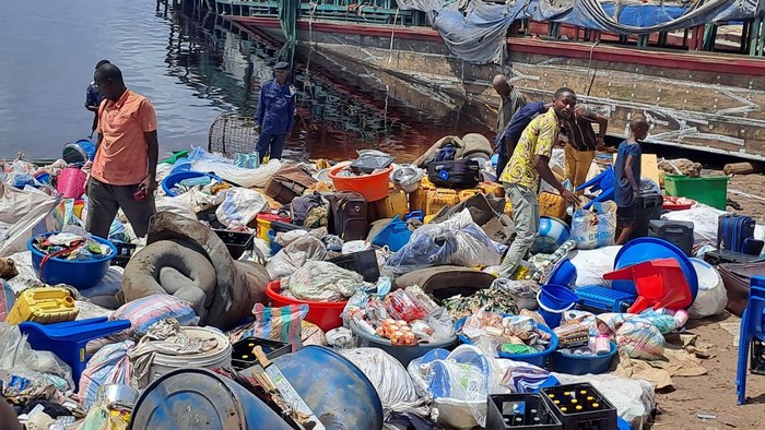 People stand among the belongings of the passengers of the boat capsized on the Congo river in Mbandaka, Democratic Republic of Congo October 16, 2023. REUTERES/Stringer NO RESALES. NO ARCHIVES