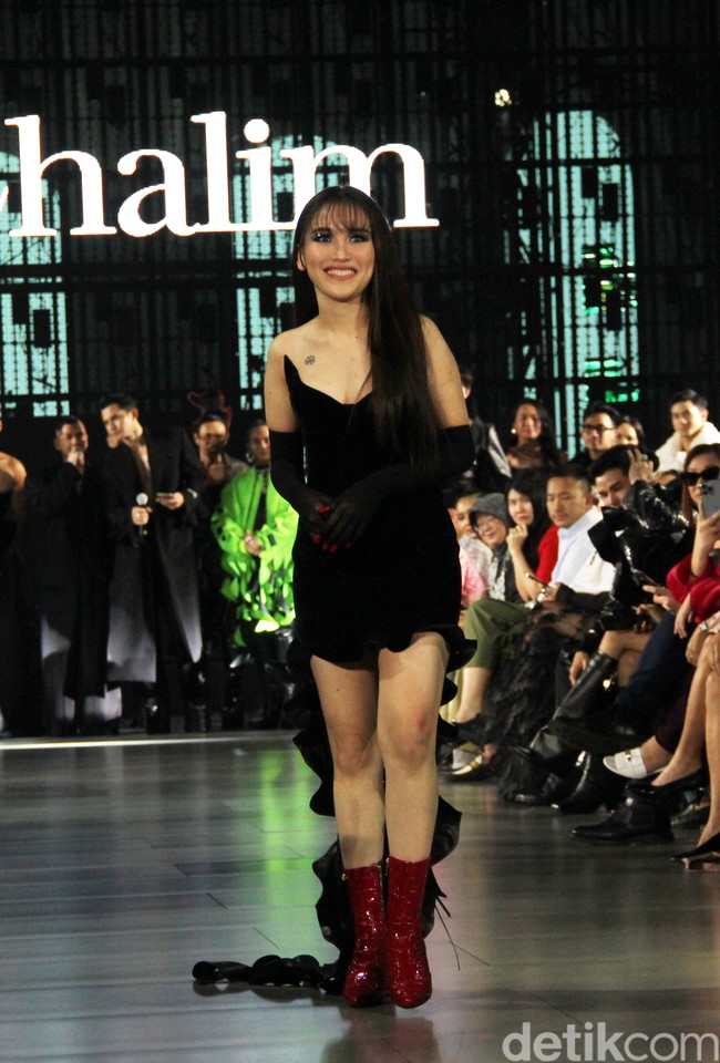 Turut melengkapi gaya perempuan 31 tahun itu, sarung tangan panjang dengan kuku merah yang terekspos. Tidak ketinggalan boots kulit senada yang catchy. (Foto: Abduh/detikcom)