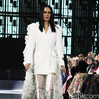 Busana tersebut dilengkapi semacam jubah dengan ekor panjang ruffle yang menjuntai hingga menyapu lantai. Kesan dramatis pun terpancar. (Foto: Abduh/detikcom)