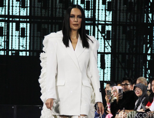 Aktris dan model lawas itu berkesempatan memeregakan tren busana pantless yang belakangan mendominasi panggung mode dunia. Dress putih berpotongan blazer dipakainya tanpa bawahan.  (Foto: Abduh/detikcom)