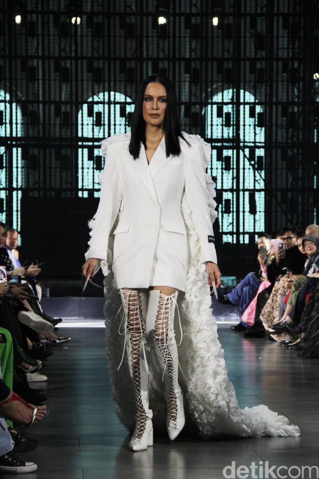 Gaya ibu dua anak itu kian sempurna berkat sepasang high-knee boots penuh temali yang menopang kaki jenjangnya. (Foto: Abduh/detikcom)