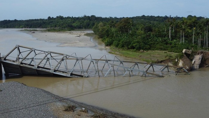 Jembatan rangka baja ambruk di Nagan Raya Sejumlah warga melihat konstruksi jembatan rangka baja penghubung Desa Alue Buloh dan Desa Krueng Mangkom yang ambruk di Kecamatan Seunagan, Nagan Raya, Aceh, Rabu (18/10/2023). Jembatan rangka baja dengan panjang 150 meter tersebut ambruk pada Selasa (17/10/2023) akibat beton penahan jembatan terkikis air dan menyebabkan terganggunya aktivitas perekonomian masyarakat sekitar yang mengharuskan warga menggunakan jalur alternatif lain dengan jarak tempuh sekitar 40 kilometer. ANTARA FOTO/Syifa Yulinnas/foc.