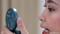 “Untuk penampilan kita mulai dari make up, warna sepatu sampai posisi name tag semua sudah ada standarnya, kita tinggal mengikuti saja jadi tidak melenceng,” kata Nadila sambil membantu memasangkan hair net di rambut rekan kerjanya. Untuk merk hair spray yang ia gunakan, Nadila dan rekan-rekannya sampai harus membelinya dari Australia. “Kita jastip soalnya merk ini nggak dijual di sini. Cuma merk ini yang kena angin pun tetap tahan. Antibadai ini.”  