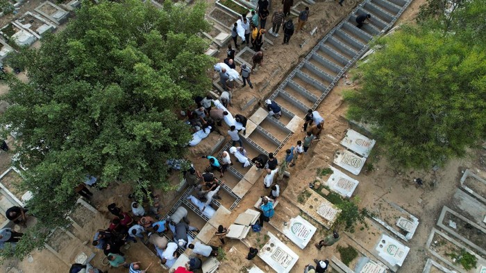 Pemakaman 11 Anggota Keluarga yang Tewas dalam Serangan Israel Mourners bury the bodies of Palestinians from Zraiee family, who were killed in Israeli strikes, at a cemetery in the central Gaza Strip, October 17, 2023. REUTERS/Mohammed Fayq Abu Mostafa