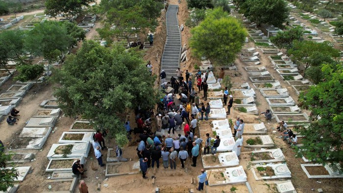 Pemakaman 11 Anggota Keluarga yang Tewas dalam Serangan Israel Mourners bury the bodies of Palestinians from Zraiee family, who were killed in Israeli strikes, at a cemetery in the central Gaza Strip, October 17, 2023. REUTERS/Mohammed Fayq Abu Mostafa