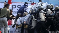 Terlihat massa aksi mendorong petugas yang tengah berjaga dan mencoba merangsek masuk ke kantor KPU. Mereka juga terlihat melemparkan botol minuman dan barang lainnya. 