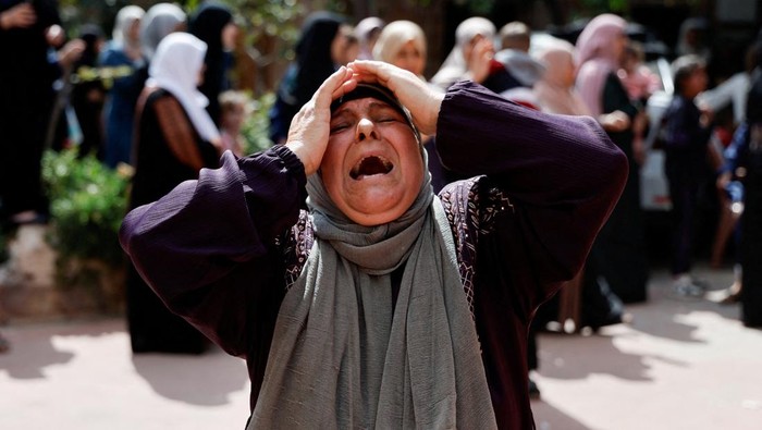 Tangis Pilu Warga Gaza Kala Rumah Hancur dan Keluarga Tiada A woman reacts as mourners attend the funeral of four Palestinians killed in clashes with Israeli settlers, near Nablus in the Israeli-occupied West Bank October 12, 2023. REUTERS/Ammar Awad TPX IMAGES OF THE DAY