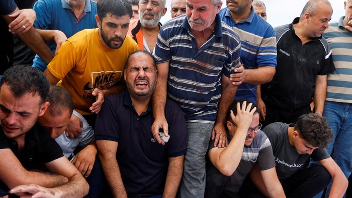 Tangis Pilu Warga Gaza Kala Rumah Hancur dan Keluarga Tiada Mourners react during the funeral of Palestinian members of al-Agha family, who were killed in Israeli strikes, in Khan Younis in the southern Gaza Strip October 11, 2023. REUTERS/Ibraheem Abu Mustafa TPX IMAGES OF THE DAY