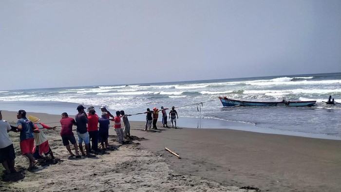 Warga bersama tim SAR gabungan menarik perahu yang terbalik di perairan Pantai Wagir Indah, Desa Welahan Wetan, Kecamatan Adipala, Cilacap, Rabu (18/10/2023).