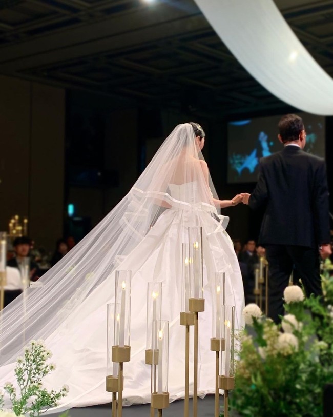 Yookyung mewanti-wanti penggemar bahwa dia akan mengunggah banyak foto pernikahannya. Dimulai dengan foto ayahnya berjalan menggandengnya di altar. Yookyung terlihat menawan dalam balutan gaun pengantin dan veil panjang.    Foto: dok. Instagram @yukyung_922