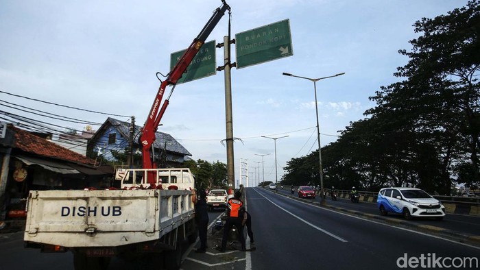 Petugas Dishub menurunkan papan rambu penunjuk jalan di Kawasan Banjir Kanal Barat, Jakarta (19/10/2023). Papan rambu penunjuk jalan itu dicabut karena goyah saat tertiup angin.