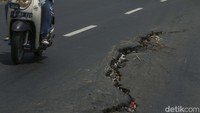 Jalan yang ramai dilalui pengendara ini nampak memprihatinkan. Jalan tersebut nampak rusak dan memiliki ketinggian berbeda.    