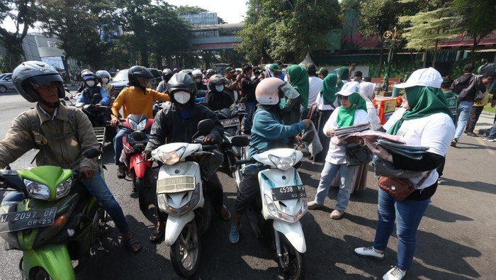 Kader PKB membagikan kerudung dan kaus saat AMIN daftar ke KPU