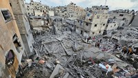 Warga Palestina berkumpul di lokasi serangan Israel terhadap rumah-rumah di Jabalia di Jalur Gaza utara, Kamis (19/10/2023). Warga bergegas ke lokasi untuk mencari korban yang selamat.