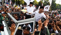 Anies dan Cak Imin sempat tertahan di atas mobil setibanya di KPU. Massa pendukung keduanya terlihat semakin memadati lokasi. 