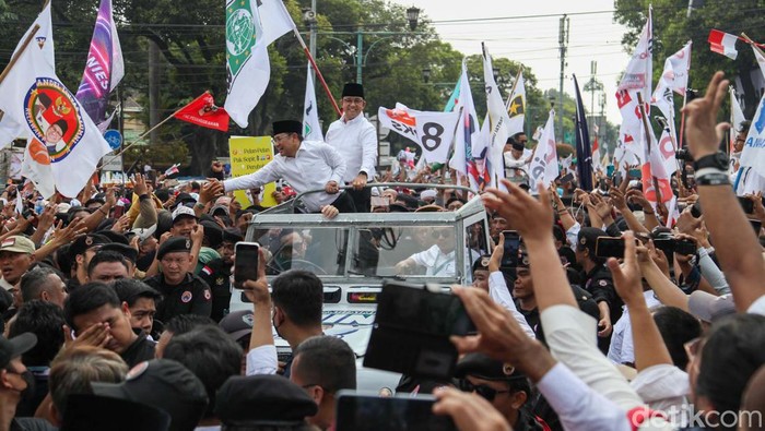 Anies Baswedan dan Muhaimin Iskandar (Cak Imin) naik Land Rover atap terbuka konvoi pendaftaran capres-cawapres di KPU, Jakarta. Mereka menyapa pendukungnya yang sudah menunggu.